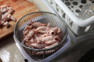 Salted Squid Drained on Wire Backet after Boil, Step Process before Cooking photo