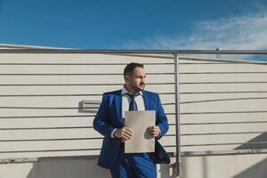 Businessman Wearing A Blue Suit Working Outdoor In The Morning photo