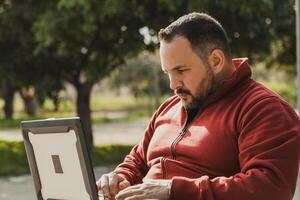 Man Working In Remote At The Park During The Day photo
