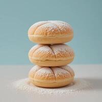 Stack of Round Buns Dusted with Powdered Sugar on White Surface photo