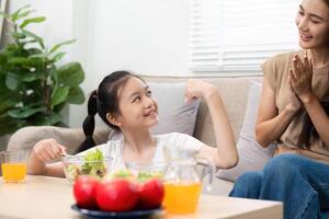 Wellness and strength Daughter showing muscles with mothers support photo