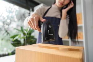 Close-up of e-commerce businesswoman scanning a package using a barcode scanner in a modern workspace. photo