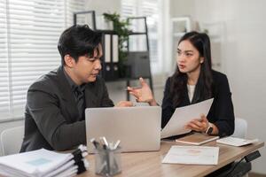 Business partners reviewing financial data and discussing strategies in a modern workspace. photo