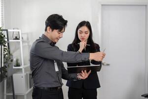 Business professionals analyzing data in a modern office, demonstrating focus and problem-solving skills. photo