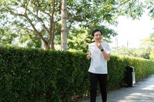 Wellness and Running. Senior man jogging in a park path. photo