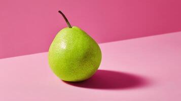 A single green pear on a pink background photo