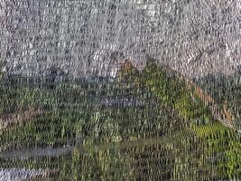 Abstract View Through a Paranet Net Reflecting Greenery and Sky photo