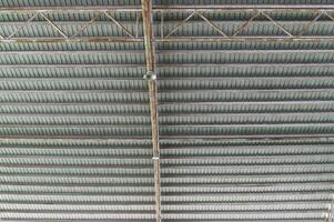 Industrial ceiling with exposed beams and structural elements in modern building, showing metal framework and lighting fixtures in organized pattern photo