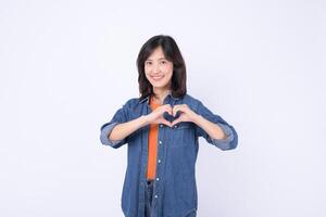 Southeast asian woman smiling warmly and making heart shape with her hands for advertising positive message of love and kindness photo