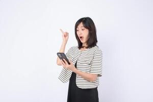 Southeast asian woman looks surprised while using mobile phone to access internet application showing excitement and discovery in bright studio setting photo