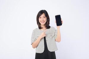 Southeast asian woman happily points at mobile phone screen showing internet application, demonstrating excitement and ease of use in bright studio setting photo