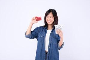 Southeast asian woman smiles happily holding credit card and cash money showing internet mobile application payment options for convenient financial transactions and shopping photo