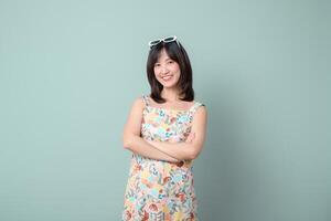 Southeast asian woman smiling confidently colorful dress with sunglasses her head advertising positivity and style front of plain background photo