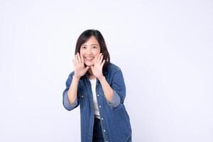 Southeast asian woman smiling and holding hands near face in cheerful expression wearing casual denim shirt standing against white background photo
