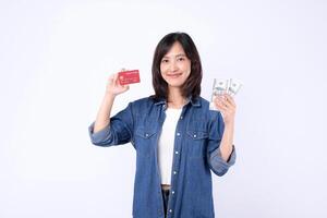 Southeast Asian woman smiling holding credit card and cash money showing internet banking and mobile payment application concept for financial transaction and digital economy photo