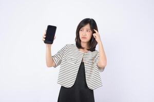 Southeast asian woman looks confused while holding mobile phone showing internet application on white background expressing uncertainty and curiosity photo