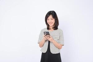 Southeast asian woman happily using mobile phone to access internet application in bright setting with casual striped jacket and black dress photo