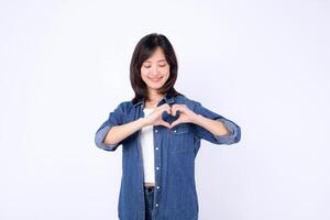 Southeast asian woman wearing denim shows heart shape with her hands smiling gently in bright advertising style portrait image photo