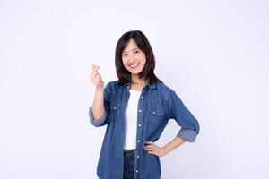 Southeast asian woman smiling and making heart gesture in advertising concept with casual denim shirt on white background photo