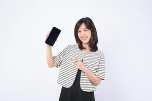 Southeast asian woman happily points at mobile phone screen showing internet application, demonstrating excitement and engagement with digital technology in bright setting photo