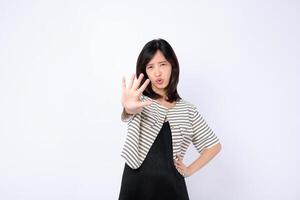Southeast asian woman in advertising style poses with serious expression showing stop gesture with her hand in front of white background photo