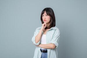 Southeast asian woman with thoughtful expression is considering ideas for her small business startup in creative retail industry while shopping online store options photo
