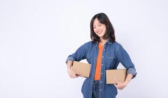 Southeast asian woman happily holding two cardboard boxes while shopping online enjoying convenience and excitement of receiving packages at home photo