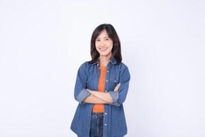 Southeast asian woman smiling confidently in casual denim clothing posing for advertising with arms crossed and bright cheerful expression photo