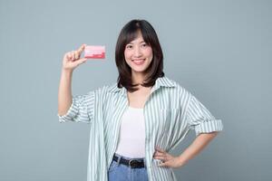 Southeast asian woman shopping online holding credit card smiling happily in casual outfit photo