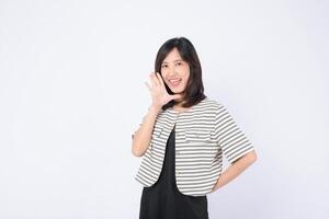 Cheerful southeast asian woman in striped jacket smiling and advertising with hand gesture on white background for marketing use photo