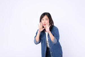 Southeast asian woman in denim jacket is advertising with playful expression using her hands near her mouth on white background photo