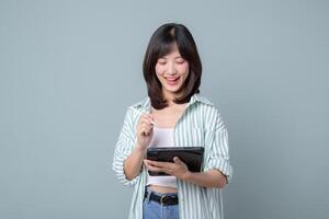 Southeast asian woman is happily using digital tablet for her small business startup in creative retail industry managing online store with focus and joy photo