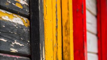 A close up of weathered wooden planks painted in black yellow and red colors photo
