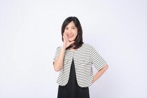 Southeast Asian woman in striped jacket smiling and holding hand near mouth as if calling out, standing against white background, expressing cheerful emotion photo