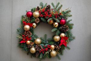 Festive Christmas Wreath with Red and Gold Decorations, A traditional Christmas wreath with gold baubles photo