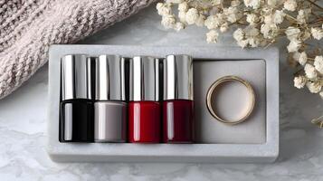 Elegant Nail Polish Colors Set with Gold Ring in Grey Box Marble Background photo
