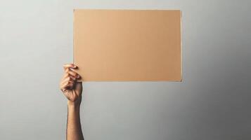 A person holding up a cardboard box with a blank space photo