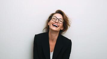 A woman wearing glasses and a black blazer is laughing photo