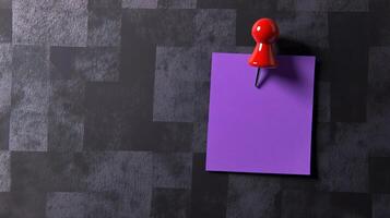 A purple paper with a red push pin on it photo
