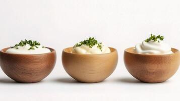 Three wooden egg cups with yogurt and herbs photo