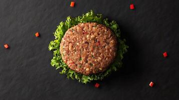 A hamburger is shown on a black surface photo