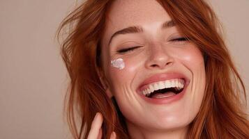 A woman with red hair smiling and holding a cream photo