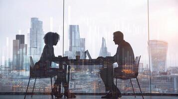 Two people sitting at a table with a cityscape in the background photo