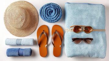 A hat, sunglasses, sunglasses, a towel, a hat and a pair of flip flops photo