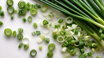 Green onions and onions are arranged on a white surface photo