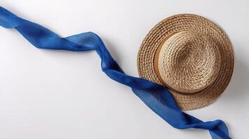 A straw hat and blue ribbon on a white background photo