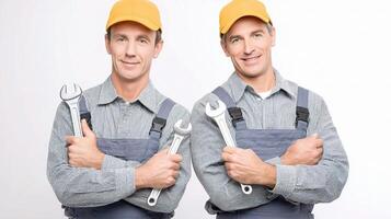 Two men in overalls holding wrenches photo