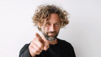 A man with curly hair pointing at the camera photo