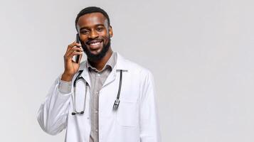 A smiling black man in a white coat talking on a cell phone photo