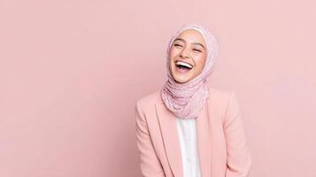 Portrait of a smiling muslim woman wearing hijab on pink background photo